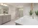 A well-lit bathroom with dual sinks, a quartz countertop, and a glass shower at 1215 Everton Ave, Durham, NC 27703