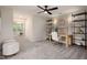 Bright bedroom featuring a ceiling fan and desk with shelving, perfect for a home office or study area at 1215 Everton Ave, Durham, NC 27703