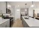 A modern kitchen with stainless steel appliances, light wood floors, and quartz countertops at 1215 Everton Ave, Durham, NC 27703