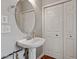 Bathroom featuring a pedestal sink, oval mirror, double door linen closet and neutral paint at 1217 Heritage Greens Dr, Wake Forest, NC 27587