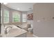 Bathroom features double sinks, a soaking tub, tiled floors, and windows for natural light at 1217 Heritage Greens Dr, Wake Forest, NC 27587