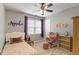 A bright bedroom with a floral bedspread, pink rocking chair, and decor at 1217 Heritage Greens Dr, Wake Forest, NC 27587