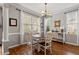 Bright dining area features large windows, hardwood floors, and a stylish chandelier at 1217 Heritage Greens Dr, Wake Forest, NC 27587