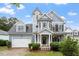 Charming blue two-story home with lush front yard and attached garage, providing curb appeal at 1217 Heritage Greens Dr, Wake Forest, NC 27587