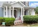 Inviting front porch with decorated entrance, lush shrubbery, and well-manicured landscaping at 1217 Heritage Greens Dr, Wake Forest, NC 27587