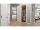 Hallway with gray walls, carpet flooring, and white doors, including a bathroom and bedroom doorway at 1217 Heritage Greens Dr, Wake Forest, NC 27587