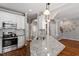 Spacious kitchen showcasing a center island, stainless appliances, white cabinets and hardwood floors at 1217 Heritage Greens Dr, Wake Forest, NC 27587