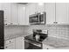 Close up of kitchen showing stainless steel appliances, granite countertops and white subway tile backsplash at 1217 Heritage Greens Dr, Wake Forest, NC 27587