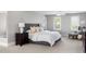 Bright bedroom featuring a gray tufted headboard, neutral walls, carpet flooring, and natural light from shuttered windows at 123 Trellingwood Dr, Morrisville, NC 27560