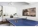 Bright game room with a ping pong table, a built-in wet bar with white cabinets and wine refrigerator at 123 Trellingwood Dr, Morrisville, NC 27560