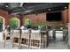 Covered outdoor kitchen with brick accents, a built-in grill, stainless steel appliances, and bar seating at 123 Trellingwood Dr, Morrisville, NC 27560