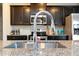 Close-up of the kitchen sink, granite countertops, stainless steel appliances, and dark wood cabinets at 1234 Sirius Drive Lot 31 Dr, Sanford, NC 27330