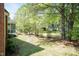 Beautiful backyard with lush greenery, mature trees, and a view of the home's exterior at 126 Solterra Way, Durham, NC 27705