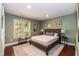 Inviting bedroom with a wooden bed frame, area rug, and ample natural light from the window at 126 Solterra Way, Durham, NC 27705