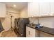 Functional laundry room with a sink, cabinets, modern washer, and dryer at 126 Solterra Way, Durham, NC 27705