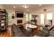 Cozy living room with a fireplace, custom shelves, and french doors to the backyard at 126 Solterra Way, Durham, NC 27705