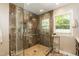 Beautiful bathroom shower featuring marble-look tile, glass door, and a window with natural light at 126 Solterra Way, Durham, NC 27705