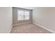 Cozy bedroom featuring neutral walls, carpet flooring, and natural light from the window at 150 Hanover Ct, Clayton, NC 27527