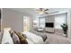 Relaxing bedroom featuring large windows for natural light, a ceiling fan, and neutral carpet at 150 Hanover Ct, Clayton, NC 27527