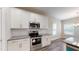 Well-lit kitchen with stainless steel appliances, white cabinets, granite countertops, and modern finishes at 150 Hanover Ct, Clayton, NC 27527