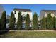 Well-maintained backyard featuring a black metal fence, lush green lawn, and privacy trees around the pool at 150 Sherrill Place Ln, Garner, NC 27529