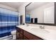This bathroom features a double sink vanity with modern fixtures and a shower-tub combination with blue curtains at 150 Sherrill Place Ln, Garner, NC 27529