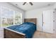 Bedroom features neutral carpet, ceiling fan, bright window, and wooden-frame bed with blue comforter at 150 Sherrill Place Ln, Garner, NC 27529