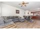 Open living space with wood floors, a gray sectional sofa, and views into the dining area and kitchen at 150 Sherrill Place Ln, Garner, NC 27529