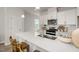 Modern kitchen featuring a large island with a sink, white cabinets, and stainless steel appliances at 1515 Tamarisk Ln, Durham, NC 27703