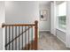 Upstairs hallway featuring wood and iron railing and natural light at 1517 Tamarisk Ln, Durham, NC 27703