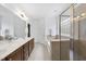 Bright bathroom featuring a soaking tub with shower and a double sink vanity with modern fixtures at 1720 Laurel Park Pl, Cary, NC 27511