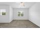 Well-lit bedroom featuring neutral carpet, a ceiling fan, and large windows overlooking green trees at 1720 Laurel Park Pl, Cary, NC 27511
