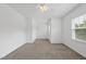 Spacious bedroom featuring neutral carpet, two windows, and a closet at 1720 Laurel Park Pl, Cary, NC 27511