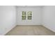 Bright bedroom with neutral carpet and large window providing natural light at 1720 Laurel Park Pl, Cary, NC 27511
