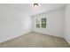 Bright bedroom featuring neutral carpet, white walls, and a window letting in natural light at 1720 Laurel Park Pl, Cary, NC 27511