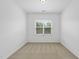 Bright bedroom featuring neutral carpet and a large window overlooking tree-lined outdoors at 1720 Laurel Park Pl, Cary, NC 27511