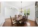 Bright dining room featuring hardwood floors, wainscoting, and a traditional chandelier, perfect for formal dining at 1720 Laurel Park Pl, Cary, NC 27511