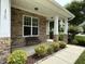 Inviting front porch featuring stone accents, a bench, and manicured shrubs, perfect for relaxing outdoors at 1720 Laurel Park Pl, Cary, NC 27511