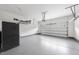 Spacious garage with sealed concrete flooring, overhead storage, and an automatic garage door at 1720 Laurel Park Pl, Cary, NC 27511