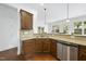 Kitchen area featuring granite countertops, stainless steel dishwasher and wood cabinets at 1720 Laurel Park Pl, Cary, NC 27511