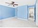 View of a bedroom with light blue walls, ceiling fan, and neutral carpet at 1728 Callandale Ave, Cary, NC 27518