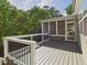 Back deck with screened porch addition, featuring a railing and natural surroundings at 1728 Callandale Ave, Cary, NC 27518