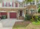 Beautiful two-story house featuring a stone facade, red shutters, brick steps, and two-car garage at 1728 Callandale Ave, Cary, NC 27518