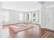 Bright living room with hardwood floors, neutral walls, large windows, and a patterned rug at 1728 Callandale Ave, Cary, NC 27518