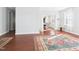 Open-concept living room featuring hardwood floors and a decorative area rug leading to the dining room at 1728 Callandale Ave, Cary, NC 27518