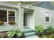 Close up of the house's entrance, with a tiled roof above the door and beautiful green plants at 1905 Bivins St, Durham, NC 27707