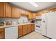 Well-equipped kitchen featuring oak cabinets, white appliances, tile flooring, and ample counter space at 1905 Bivins St, Durham, NC 27707