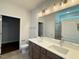 Bathroom with double sinks, granite countertops and a large walk-in closet in the background at 1998 Meadowview Dr, Graham, NC 27253
