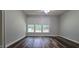 Bedroom with wood-look flooring, a ceiling fan, and a large window providing natural light at 204 Kirkwood Dr, Chapel Hill, NC 27514