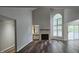 Spacious living room featuring a fireplace, tall windows, and hardwood floors, creating a cozy and bright space at 204 Kirkwood Dr, Chapel Hill, NC 27514